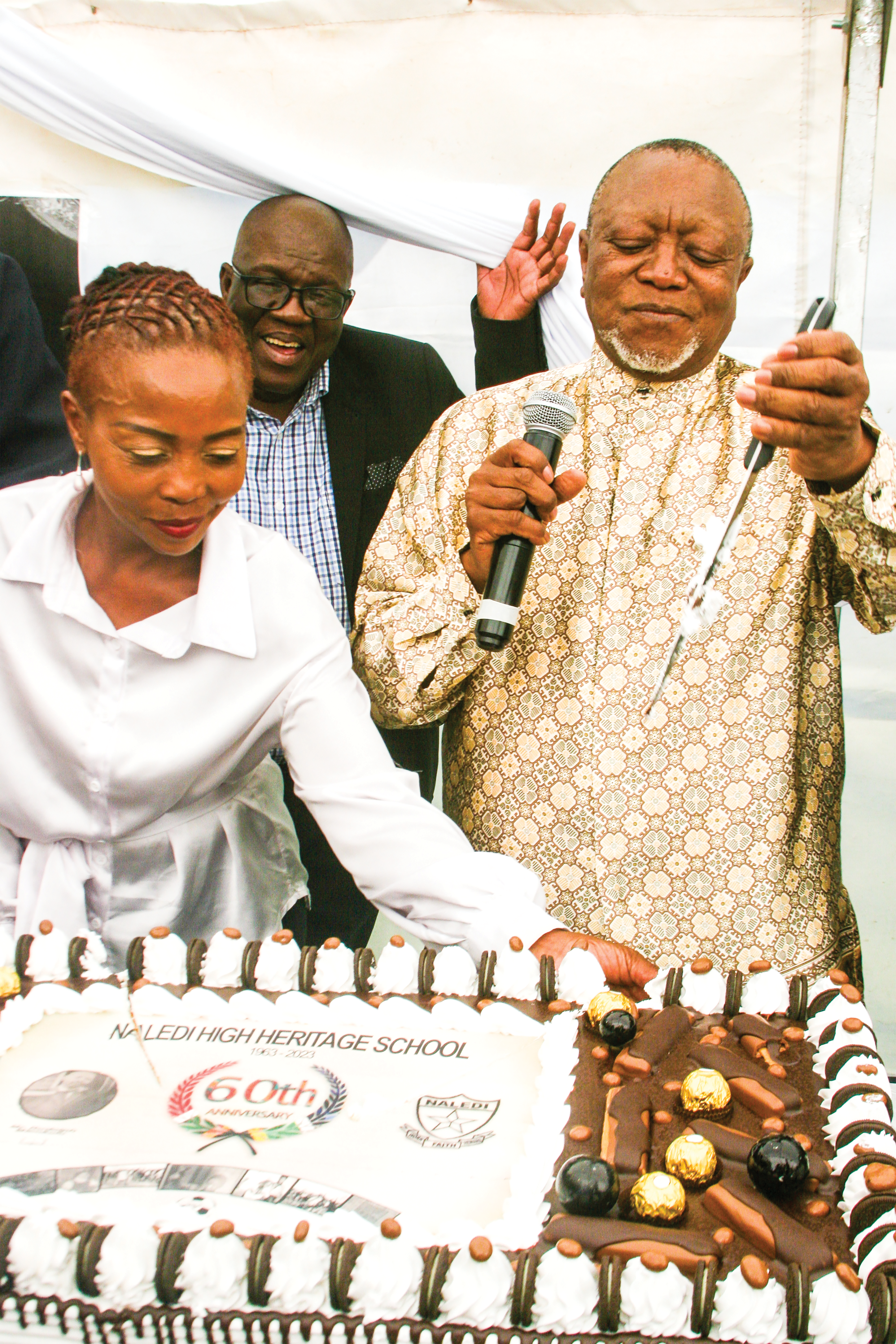 Popo Molefe slicing a cake