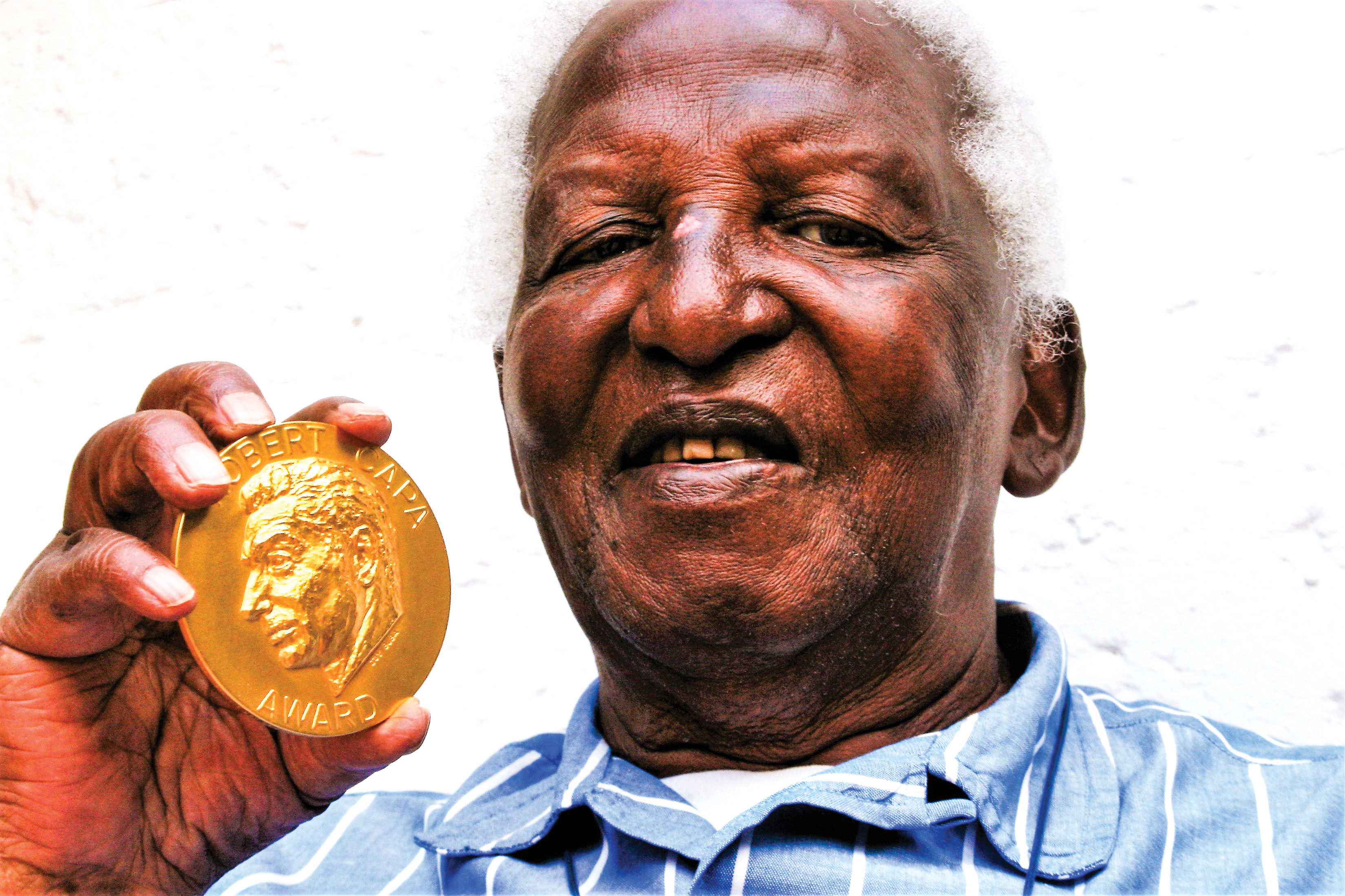 Peter Magubane showing off the Robert Capa Gold Medal he was awarded in 1985